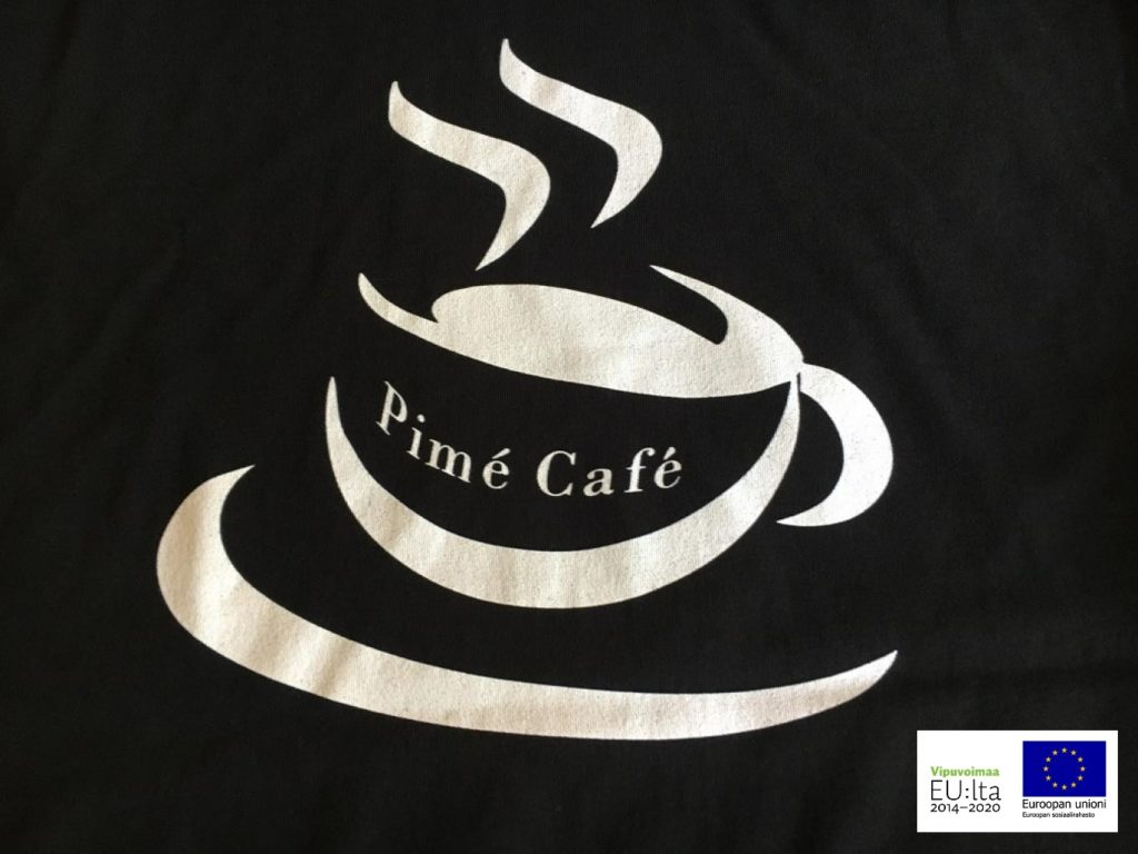 Kuvassa on mustalla pohjalla vaaleat kahvikupin ääriviivat ja teksti ”Pimé Café”. Alanurkassa on EU:n lippulogo.